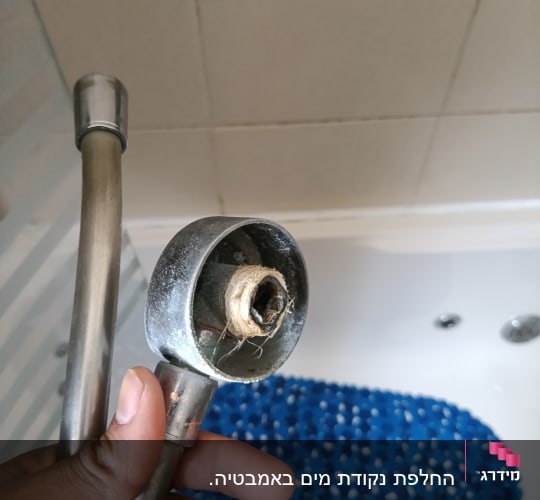 ראש מקלחת עם צינור במקלחת
